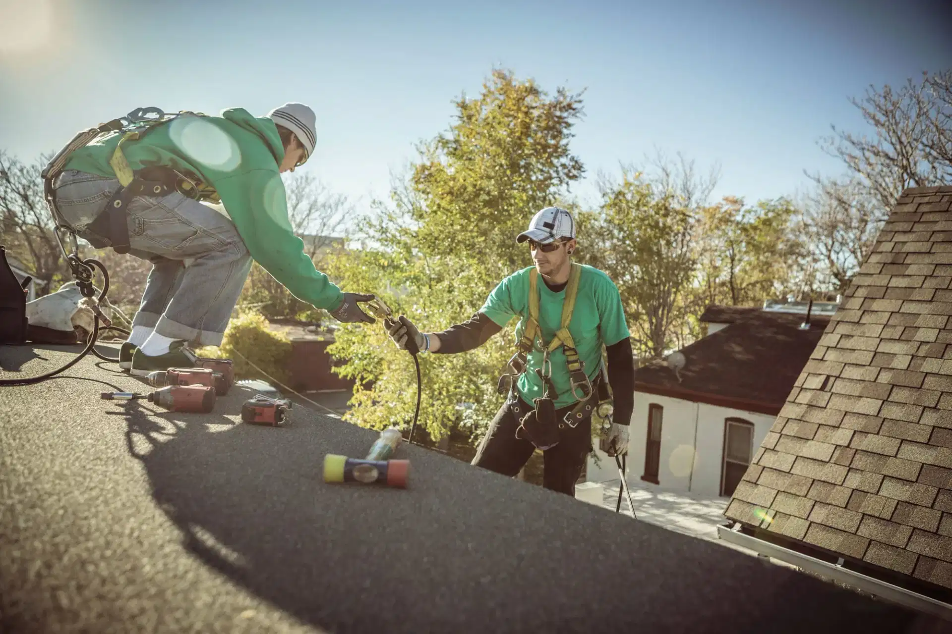 Tom Jannace roofing crew passing tools on an asphalt shingle roof