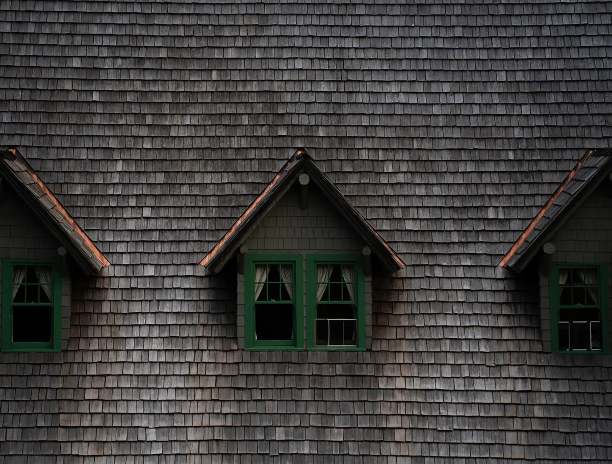 Dormers and roof-wall intersections on a shingle roof where step and chimney flashing seal out water on a Kings Park home
