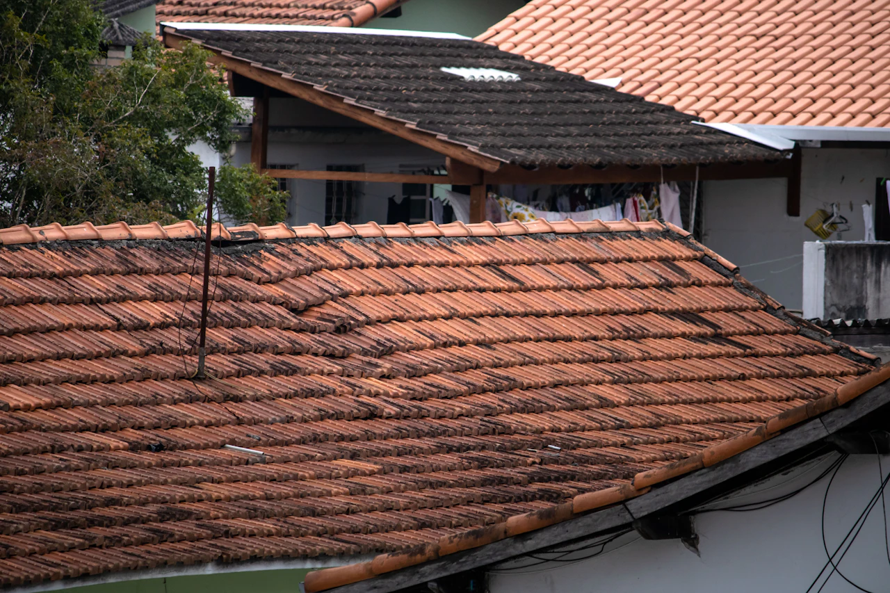 Damaged and missing asphalt shingles on a residential roof in Saint James, NY
