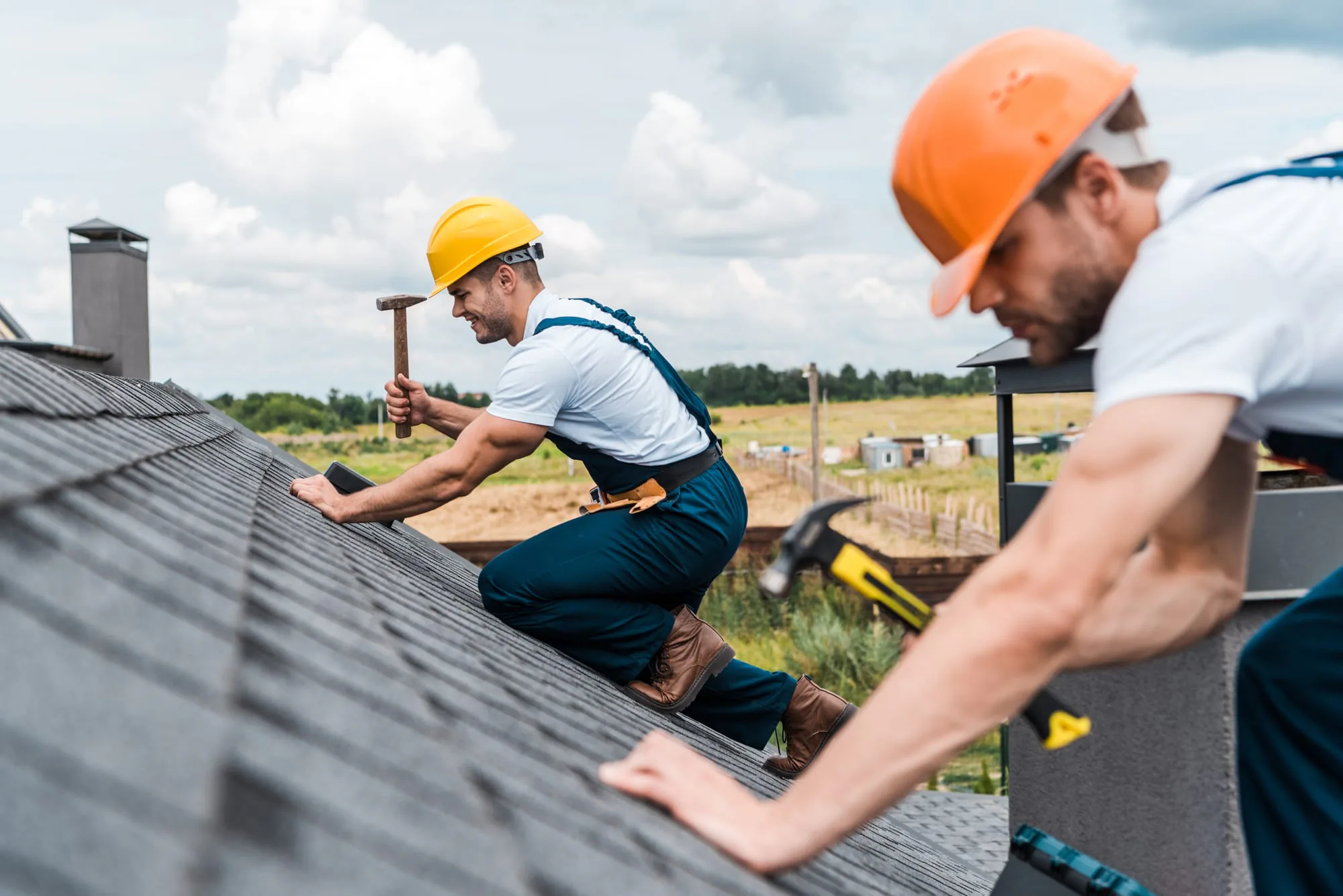 Roofers on an asphalt shingle roof