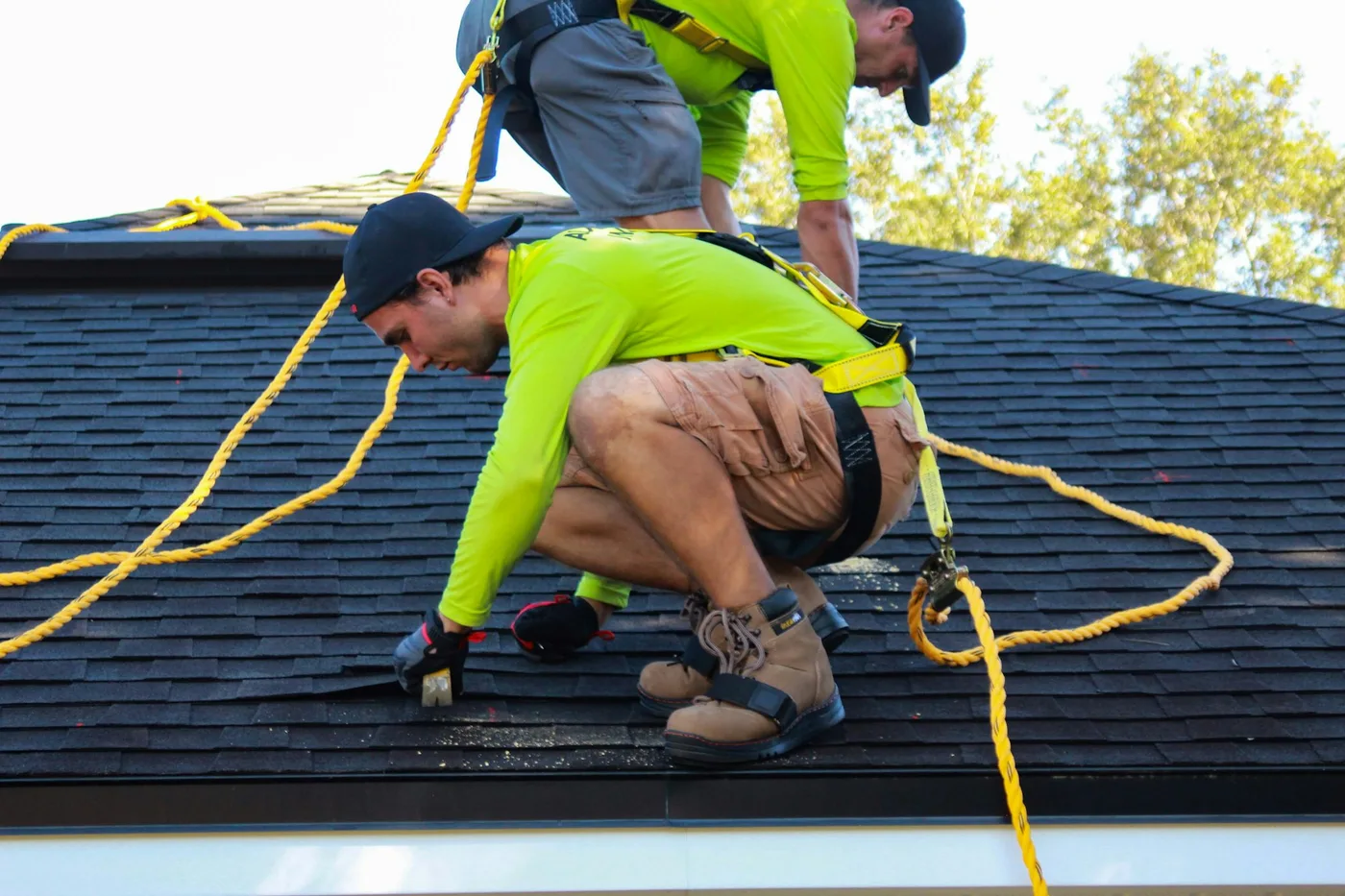Professional roofing crew repairing the asphalt shingle roof of a Nesconset, Suffolk County home