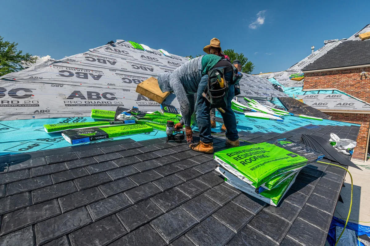 Roofer setting replacement shingles over new underlayment on a Port Jefferson home