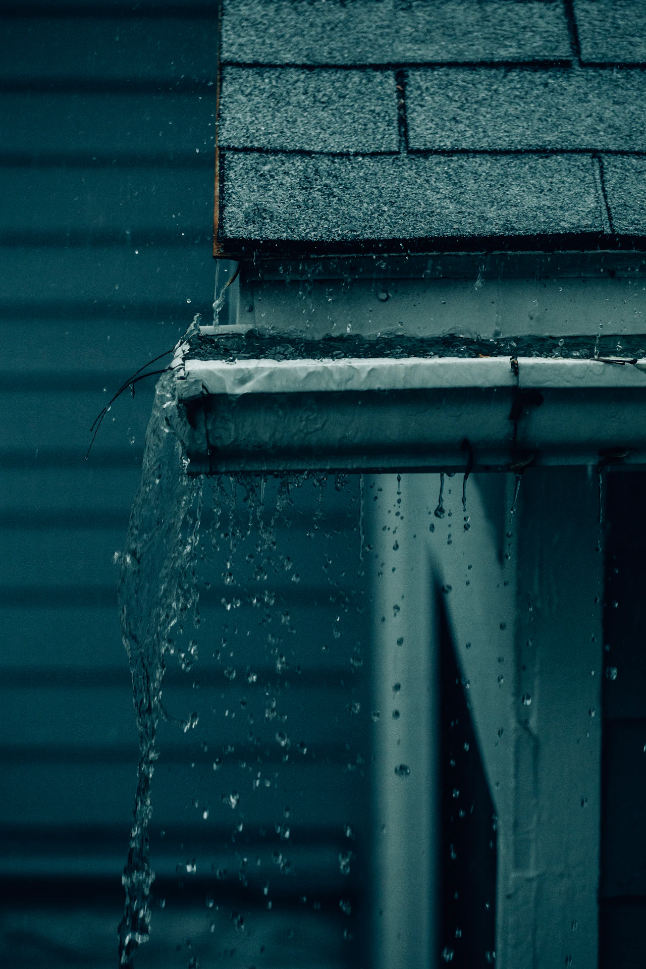 Water dripping from the edge of a roof during heavy rain in Saint James, NY