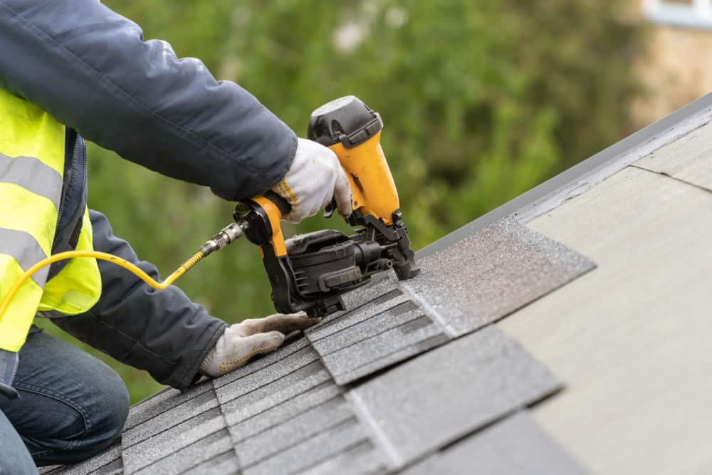 Roofer installing shingles